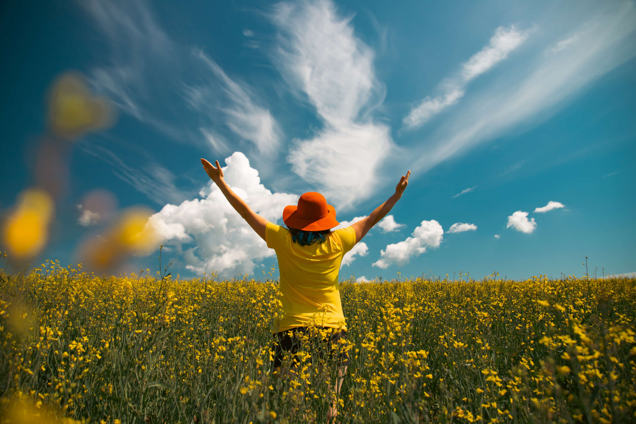 trendy woman with stylish hat feeling free in the field with flo